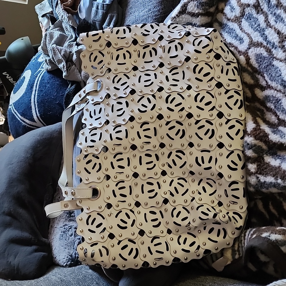 White bag with studs. Has holes with  inner line bag that snaps in